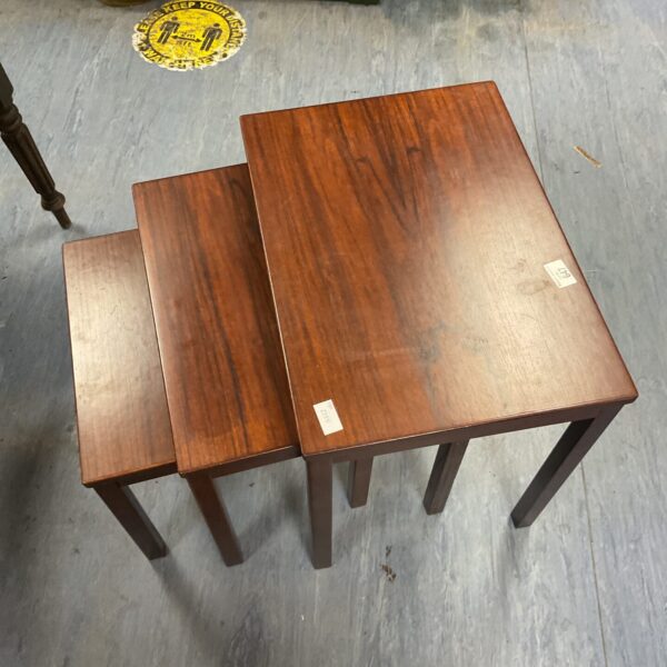 Vintage Norwegian nesting tables set in warm wood tones.