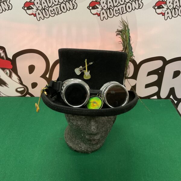 Black steampunk top hat with goggles and embellishments.