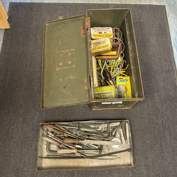 Vintage metal toolbox filled with various tools and components.