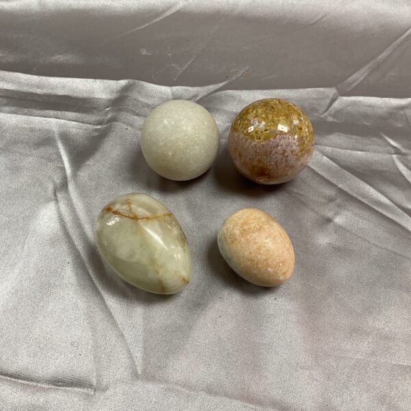 Set of polished marble balls and decorative stone eggs.