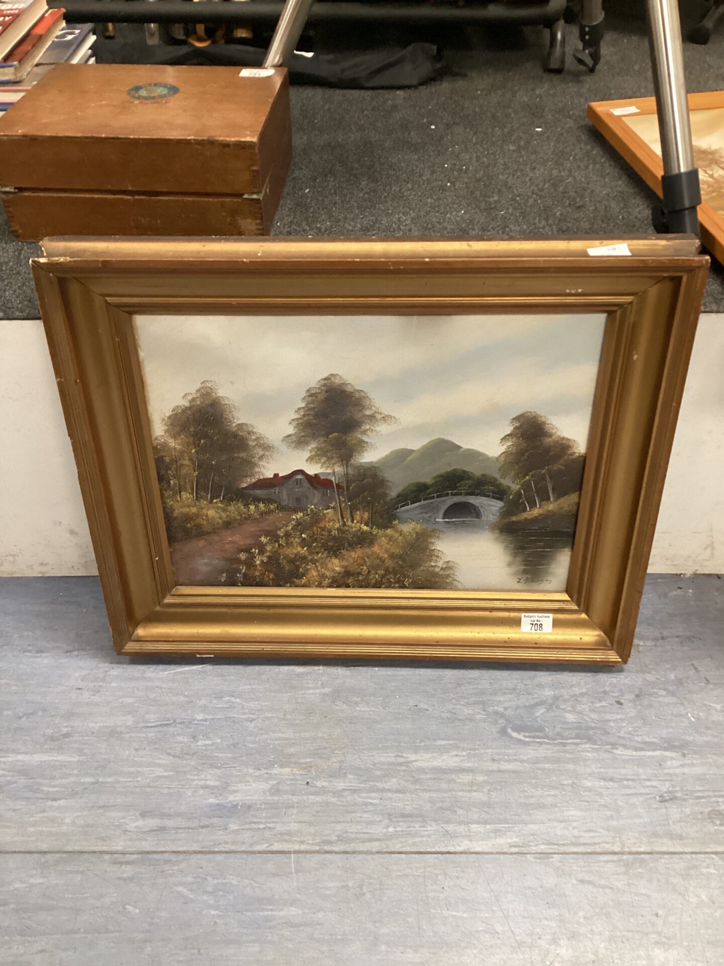 708 gilt framed oil on board of cottage by the river signed