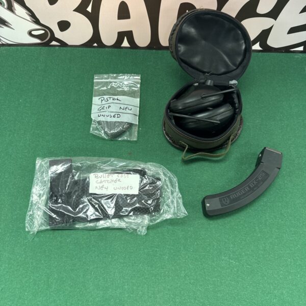 Pistol grip with bullet case catcher, ear defenders, and Ruger magazine.