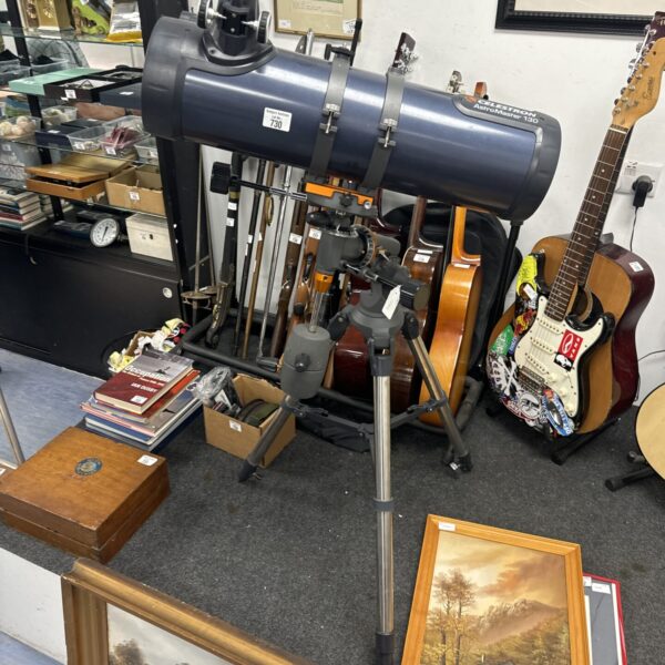 Full view of a vintage Celestron Astromaster 130 telescope with tripod.