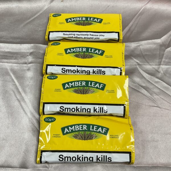Four unopened pouches of Amber Leaf rolling tobacco.