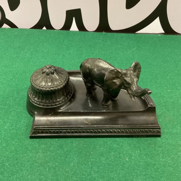 Vintage bronzed elephant inkwell on a dark surface.