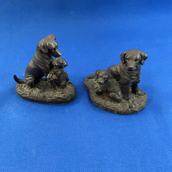 Pair of detailed resin dog ornaments for home decor.