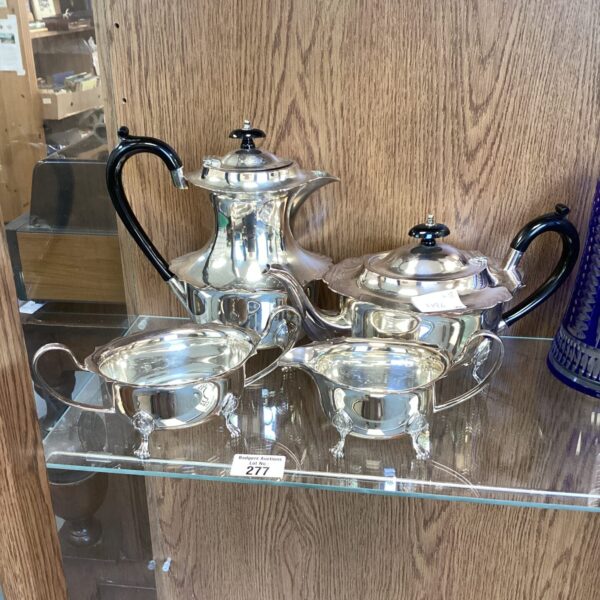 Elegant vintage silverplate tea set with teapot, cream, and sugar.