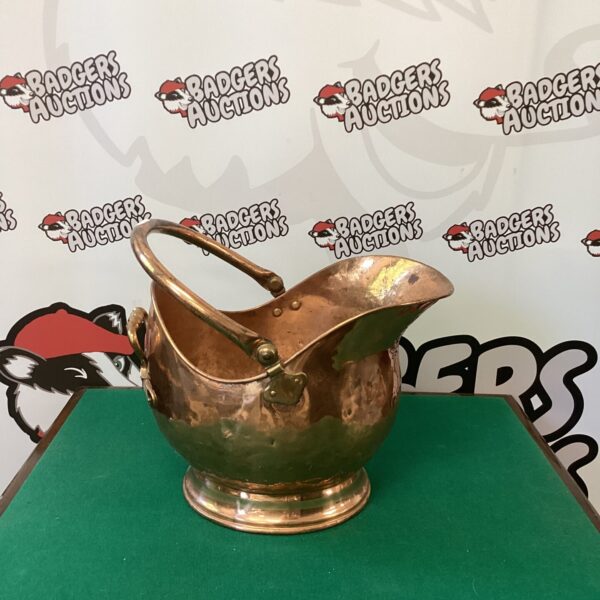 Vintage copper coal scuttle with decorative handle and feet.