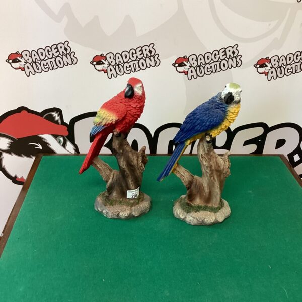 Two colourful parrot figurines on display.