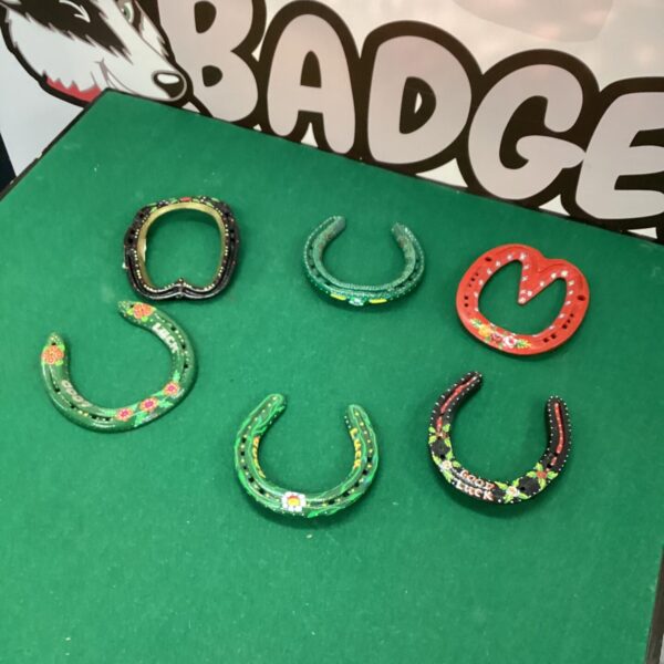 Colourful decorative horseshoes with floral patterns for rustic wall decor.