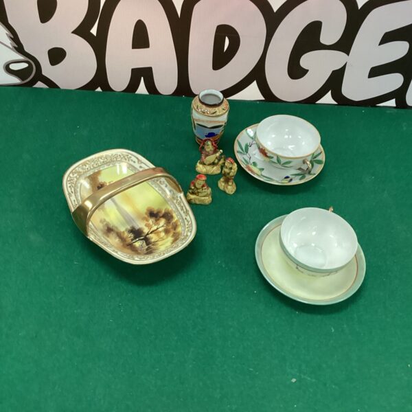 Vintage Noritake china collection with Japanese figurines on display.