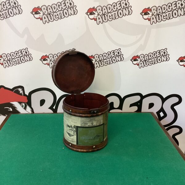 Vintage round tin storage box with decorative lithograph.
