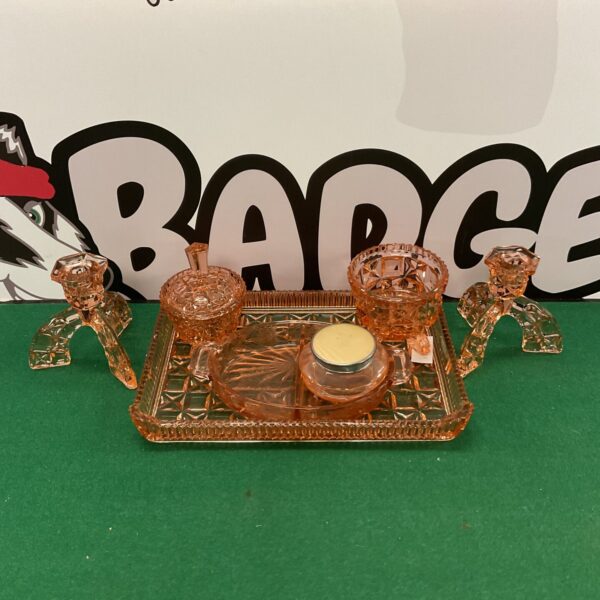 Vintage pink glass dressing table set with perfume bottle and accessories.