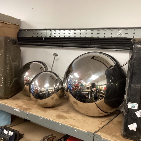 Set of three chrome garden balls for outdoor decoration.