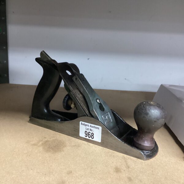 Vintage wood plane with metal body and wooden handle.