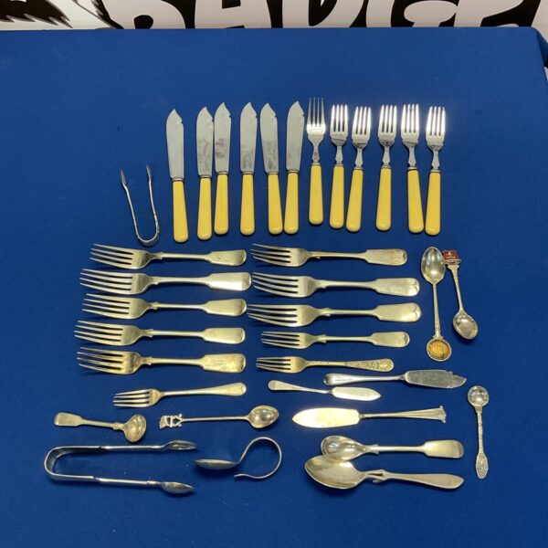 Vintage silver plate cutlery set with bone handles displayed.