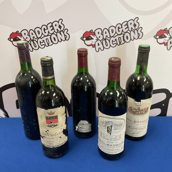 Vintage French wine bottles including Cotes du Roussillon in a collection.