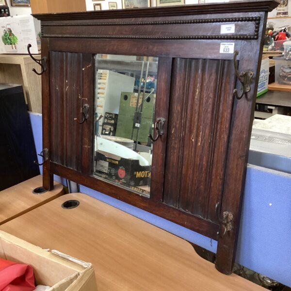 Antique mahogany coat rack with mirror and brass hooks.