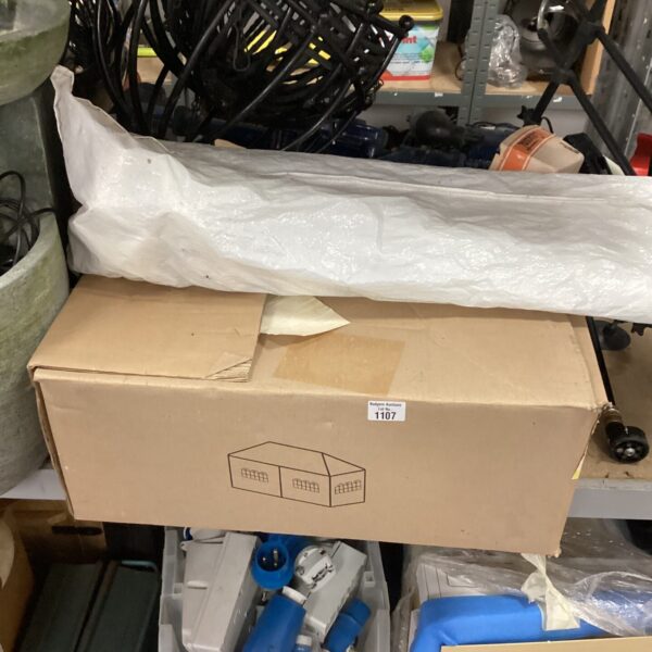 Disassembled garden gazebo kit with numerous poles and fittings.