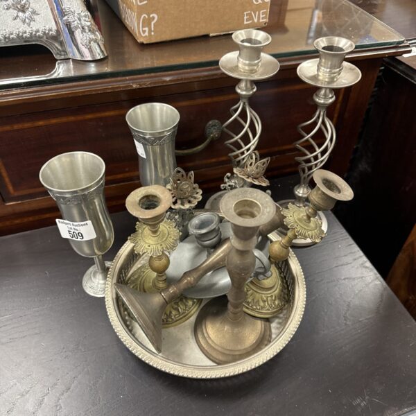 Antique silver plate tray with candlesticks and goblets on display.