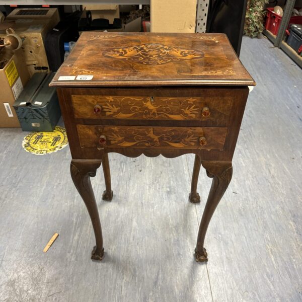 Antique inlaid sewing box with claw feet and floral design.