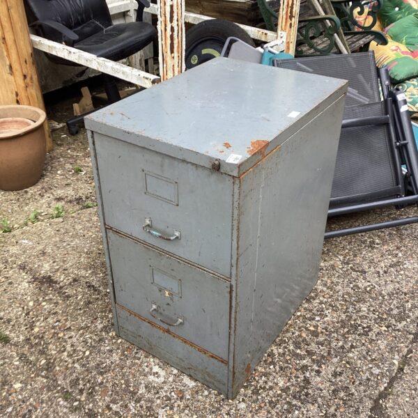 Weathered vintage metal filing cabinet with two drawers.