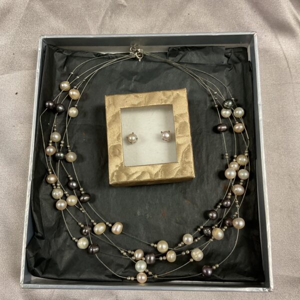 Vintage pearl necklace and earrings set on display.