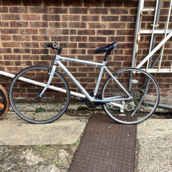 Silver Specialized Sirrus hybrid bicycle, side view.