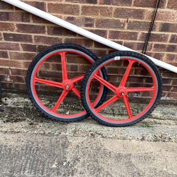 Two vintage red spoked bicycle wheels for restoration.