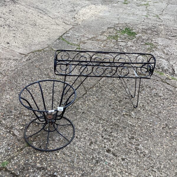 Tiered metal garden plant holders for outdoor plant display.