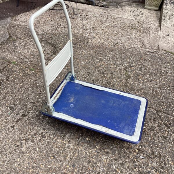 Blue platform trolley with folding handle for moving goods.
