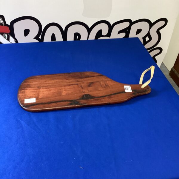 Vintage wooden cutting board with aged patina and rustic charm.