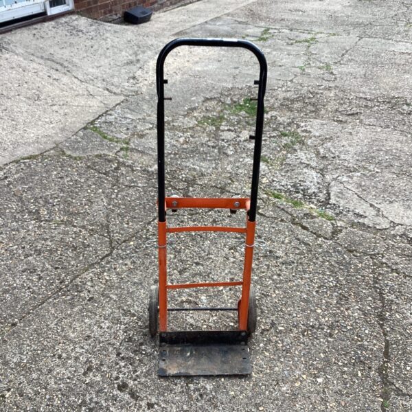 Vintage sack truck for moving heavy loads in a warehouse.