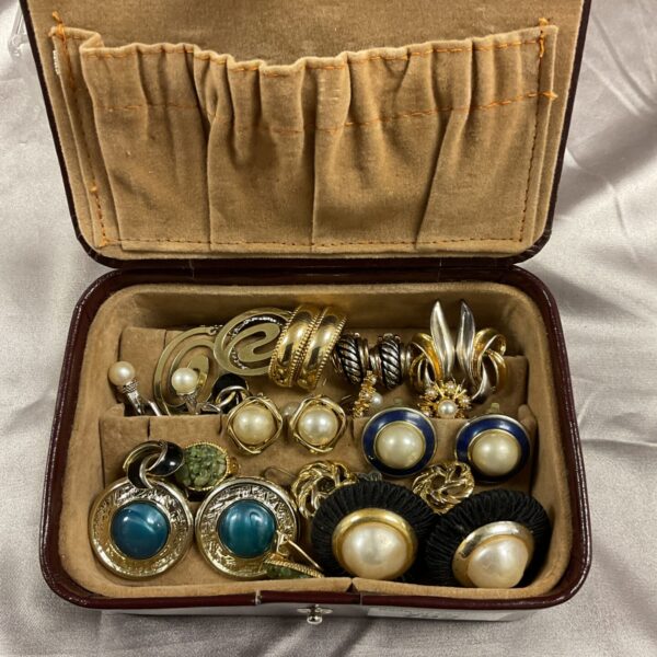 Vintage clip-on earrings lot displayed in a leather box.