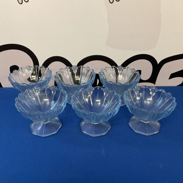 Set of six vintage blue glass dessert dishes on display.
