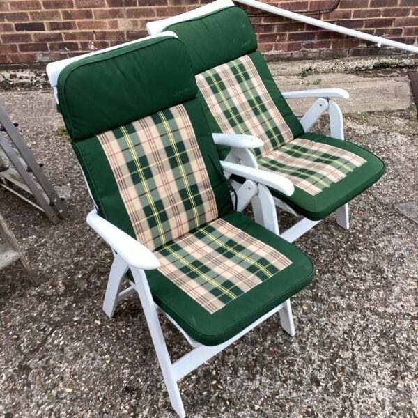 Two vintage folding garden chairs with green checked cushions.