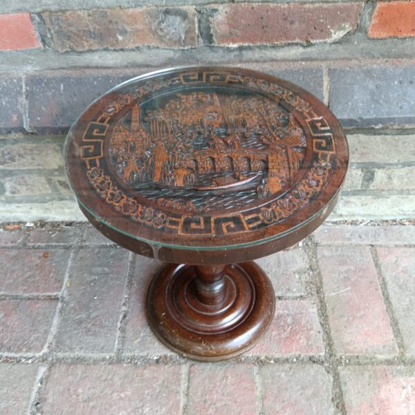 Intricately carved vintage Chinese table with detailed artwork.