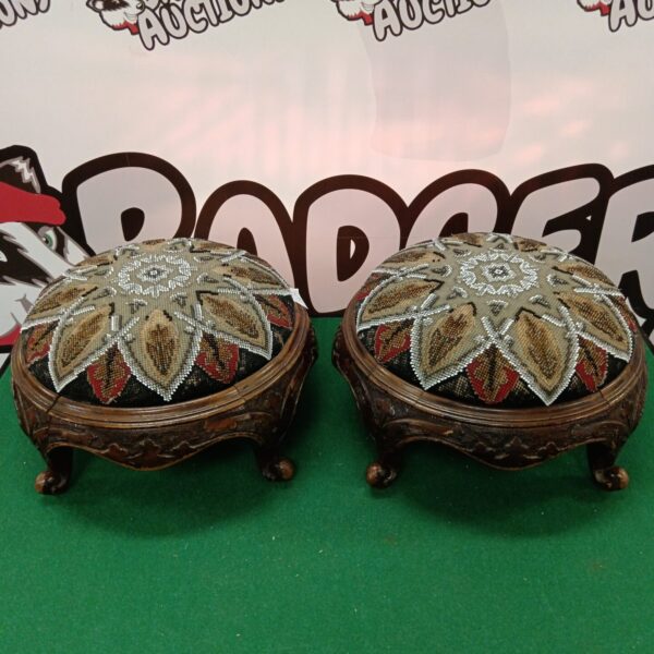 Pair of vintage beadwork pill cushions on a green surface.