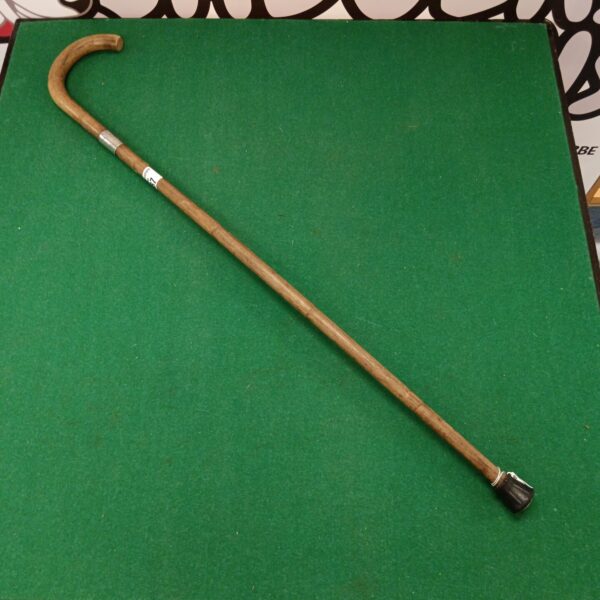 Vintage walking cane with silver cuff detail, antique style.