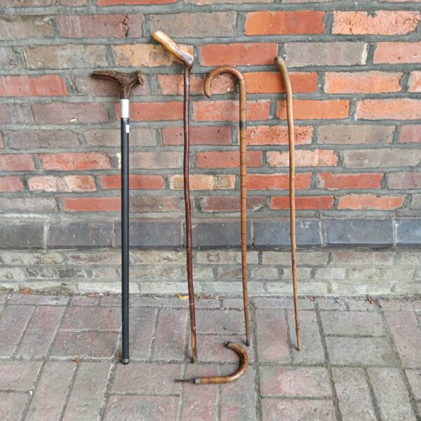 Lot of four vintage walking canes with varying styles.