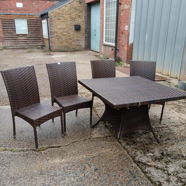 Vintage rattan garden furniture set with broken table legs.