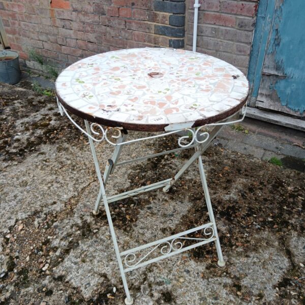 Colourful tile top garden table with wrought iron legs.