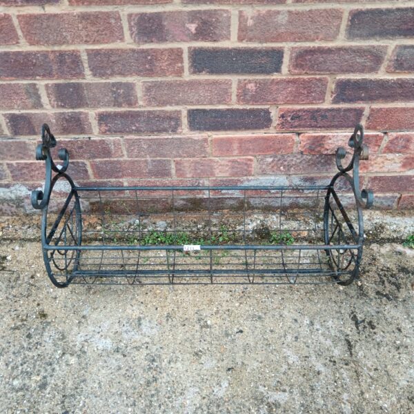 Vintage wrought iron hanging barrel planter for garden display.