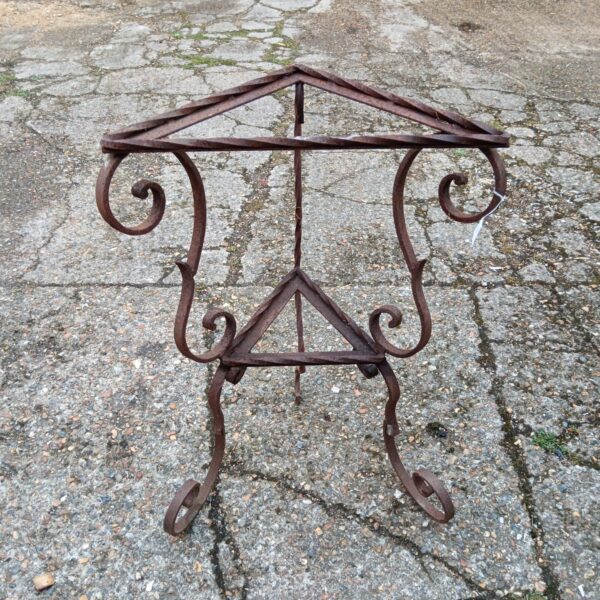 Antique wrought iron garden table with curved legs.