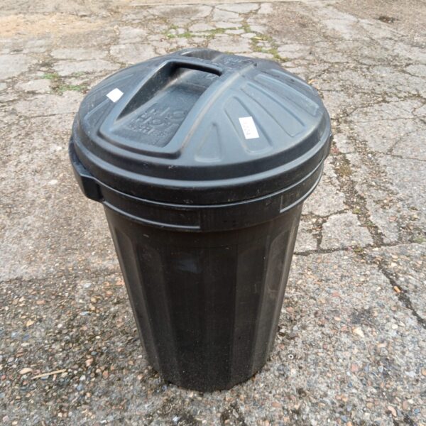 Black garden bin standing outdoors, ideal for garden waste storage.