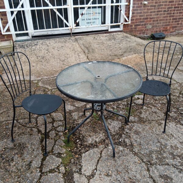 Wrought iron garden table and chairs set for outdoor use.