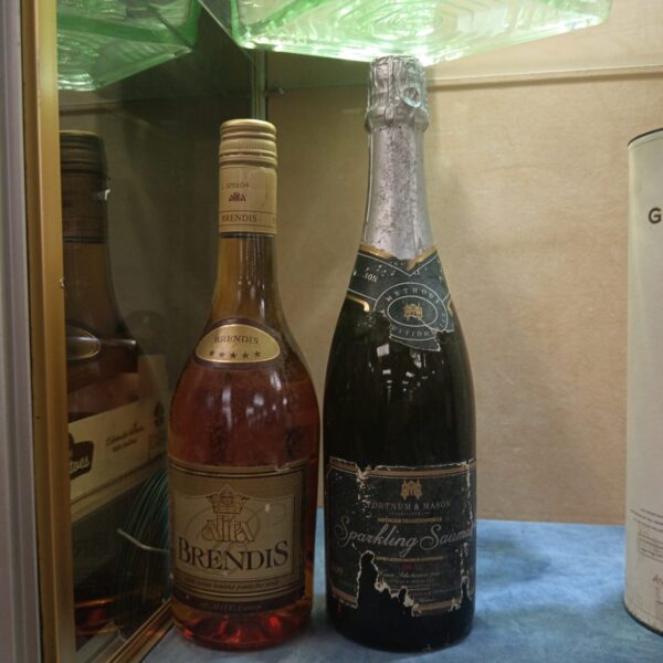 Vintage Fortnum & Mason Saumur sparkling wine and Alita Brendis brandy bottles.