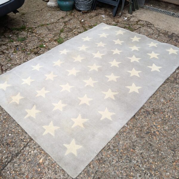 Beige and grey star pattern rug for home decor.