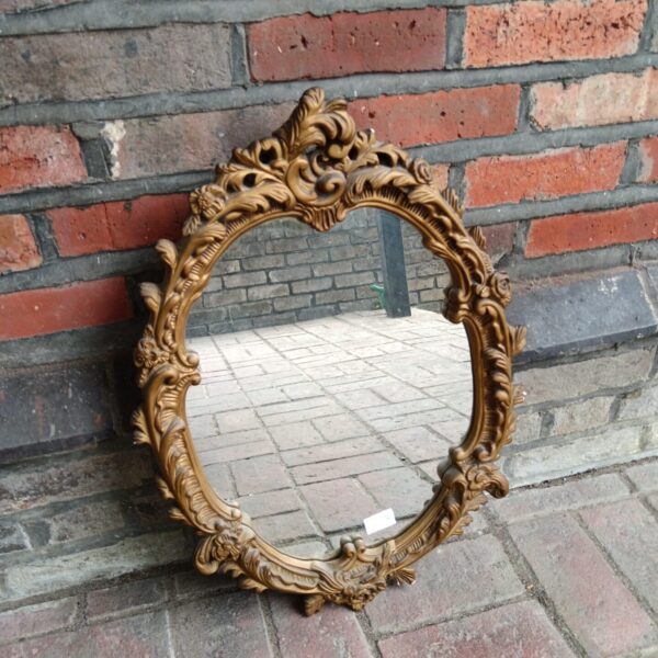 Ornate vintage gilt framed French style mirror for wall decor.