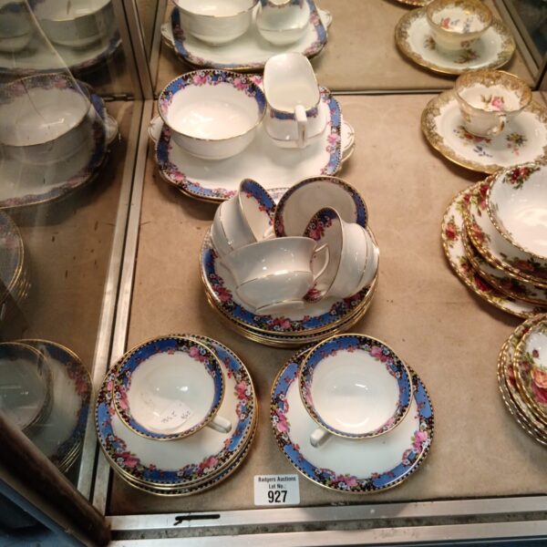 Vintage Aynsley china teaset with floral design on display.